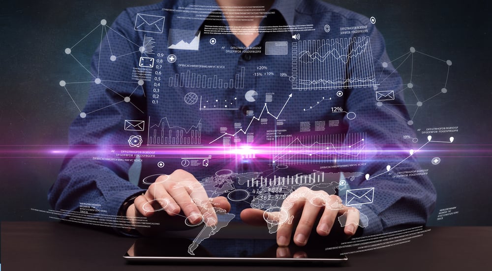 Businessman in formal attire typing with financial concept around